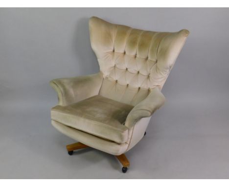A G Plan Blofeld lounge chair, upholstered in button back cream fabric, raised on an X frame teak base, on castors.