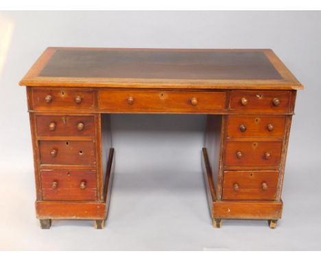 A Victorian mahogany twin pedestal desk, the top with brown leatherette inset, over one long and eight short drawers, raised 
