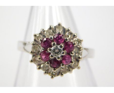 An 18ct white gold ruby and diamond flower head ring, diamonds approx 0.25cts, size K, 4.9g.