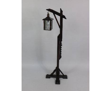 An oak lantern formed standard lamp, raised on a ratchet adjustable stem, on an X frame base, 44cm x 48.5cm x 164cm.