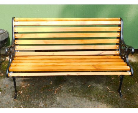 A wooden bench with black iron ends, 123cm x 56cm x 72cm.