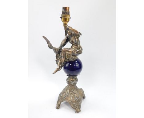 A plated and ceramic table lamp, cast as Hebe and the eagle atop a globe, raised on a rococo scroll base, 46.5cm high.