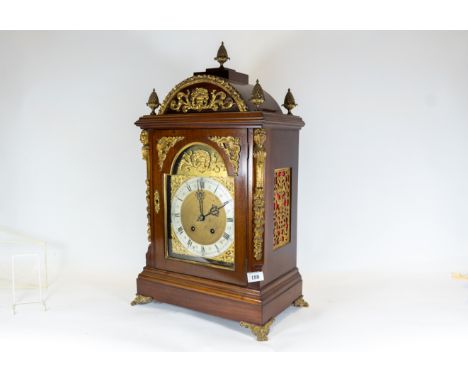 A late 19th century ornate mounted mahogany bracket clock, break arch dial with silvered chapter ring supporting a twin train