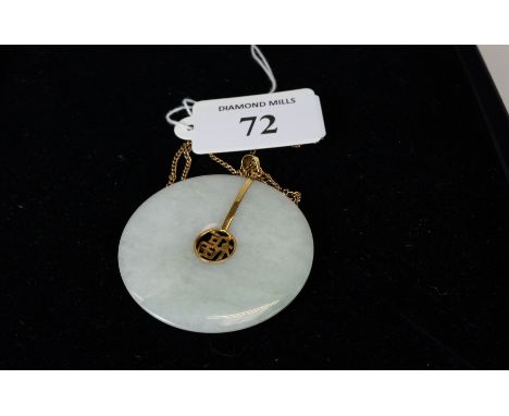 A Chinese green Jade disc pendant with 14k gold mount, on a 9ct gold neckchain, est £100 - £150 