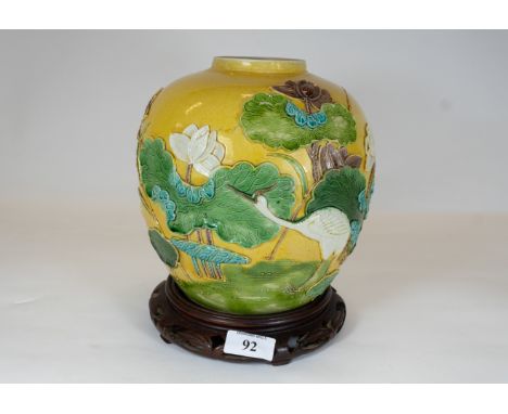 A 19th century chinese porcelain vase, mustard ground with raised decoration of a wading crane amongst water lilies, square s