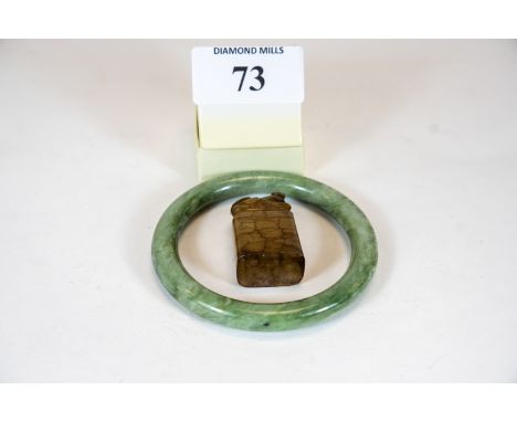 A Chinese mottled green Jade bangle and a small carved hardstone seal with dog of fo finial (2) £40 - £60