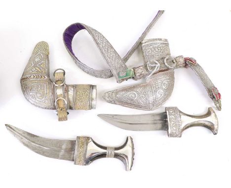 A 20th Century Omani Khanjar, the 17cm curved steel blade with raised medial ridge, the horn grip with silver mounts, the L s