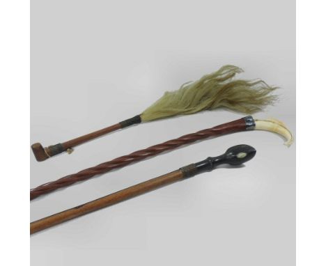 An African horse hair whisk, together with a riding crop, with a handle carved as a horses hoof and a boar tusk handled walki