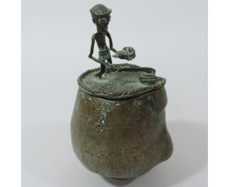 An Ashanti bronze kuduo, with geometric decoration and a removable cover decorated with a figure, 20cm tall