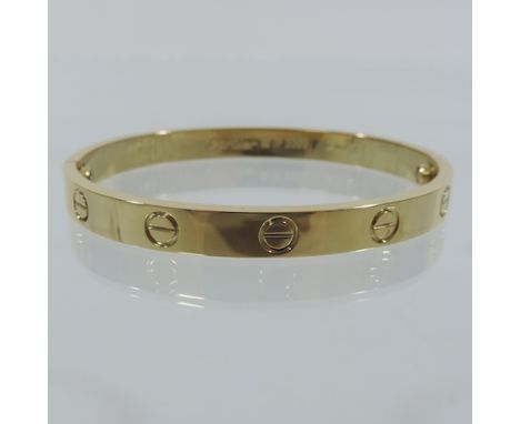 A modern gold plated hinged bangle
