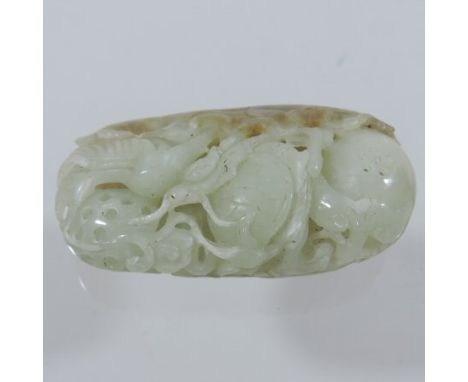 A Chinese jade coloured stone carving, of oval shape with russet highlights, decorated with birds, insects, fruit and foliage