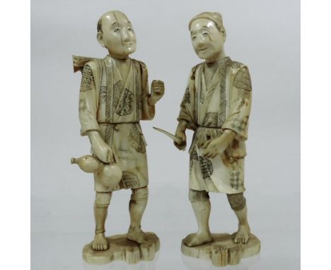 A pair of Japanese Meiji sectional carved ivory figures of men, one holding an axe, the other a water bottle, with a rucksack