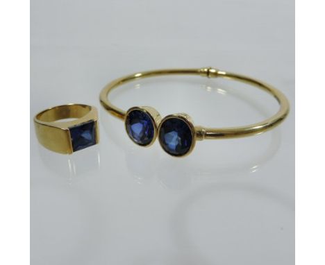 A 14 carat gold and sapphire set two stone bangle, together with a matching single stone ring