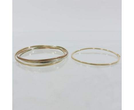 A 9 carat gold hinged bangle, together with a set of three coloured gold bangles