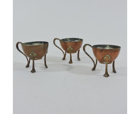 A collection of three Arts and Crafts copper egg cups, 5cm tall
