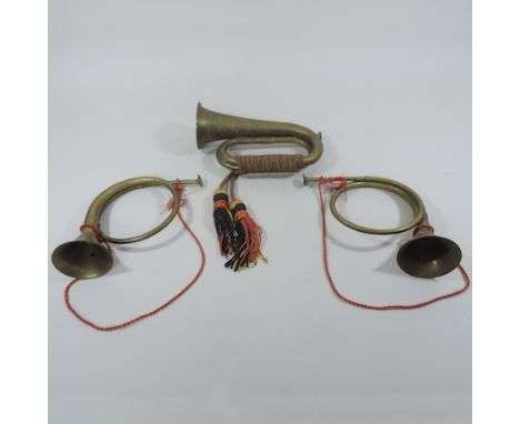 A brass bugle, together with two small French horns