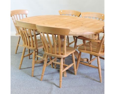 A pine table, on a pedestal base, 160 x 120cm, together with a set of six beech dining chairs, to include two carvers