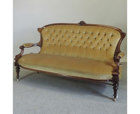 A Victorian carved walnut and gold upholstered button back sofa, on turned legs, 174cm