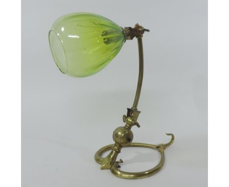 An Arts and Crafts brass adjustable desk/wall light, by W.A.S. Benson, with a green bud shaped glass shade, on a heart shaped