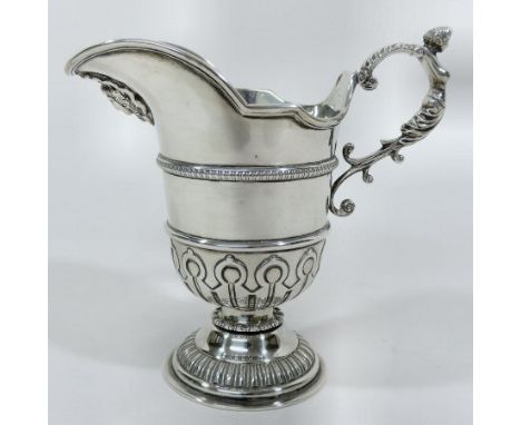 An early 20th century silver cream jug, of pedestal form with a scrolled figural handle, by Elkington & Co., Birmingham 1912,