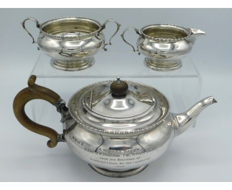 A 1923 Birmingham silver three piece tea set by William Noble with inscription 'Wedding Gift to Brother J. K. Braddon from Br