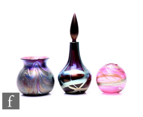 Okra - A late 20th Century glass perfume bottle of bulbous form with steel grey coloured strap decoration on dark purple grou
