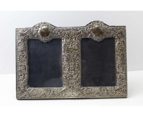 A Victorian design double silver photograph frame, London 2000,&nbsp; with embossed floral and leaf decoration, having a blue