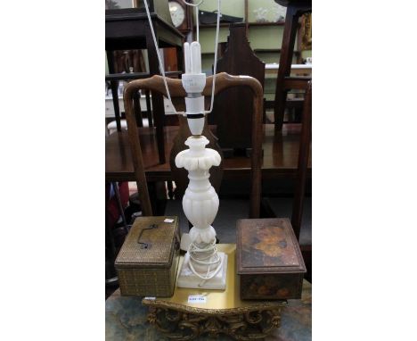 A gilt shelf, table lamp, and two tins