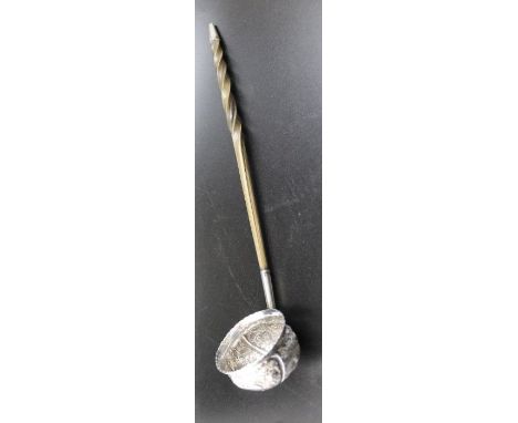 An 18th century silver toddy ladle, with embossed floral decoration, and a twisted whale bone handle, the handle 27cm long&nb
