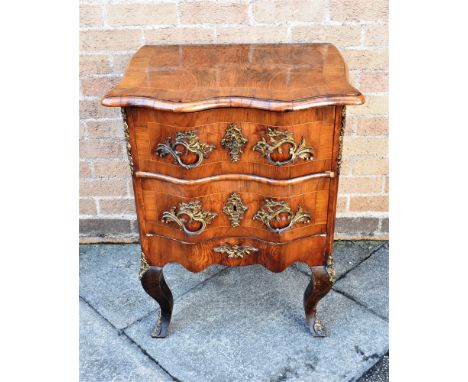 A SMALL CONTINENTAL SERPENTINE FRONT TWO DRAWER COMMODE  with rococo style gilt metal mounts, on cabriole supports, 62cm wide