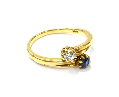 AN EARLY 20TH CENTURY GOLD, SAPPHIRE AND DIAMOND TWO STONE CROSS-OVER RING  claw set with a small round mixed-cut sapphire an