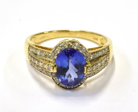 A MODERN 18CT GOLD, TANZANITE AND DIAMOND OVAL CLUSTER RING centred with an oval mixed-cut tanzanite approximately 2.06cts, c