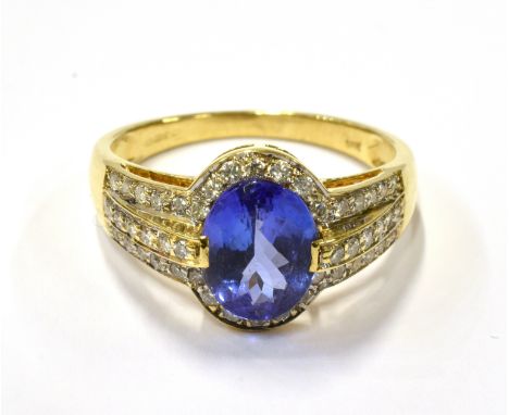 A MODERN 18CT GOLD, TANZANITE AND DIAMOND OVAL CLUSTER RING centred with an oval mixed-cut tanzanite approximately 2.06cts, c