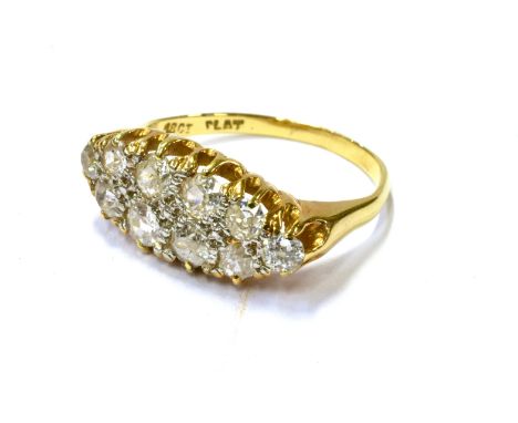  AN EARLY 20TH CENTURY GOLD AND DIAMOND OVAL CLUSTER RING designed to run across the finger, the ten old-cut stones approx. 1