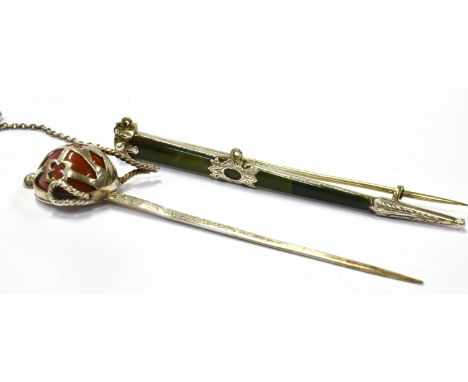 A VICTORIAN SCOTTISH PEBBLE BROOCH IN THE FORM OF A SCOTTISH BASKET HILTED BROADSWORD with a cabochon red jasper hilt within 