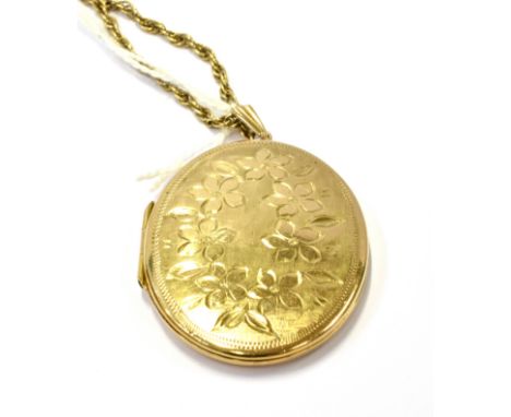 A VINTAGE 9CT GOLD OVAL PART FOLIATE ENGRAVED LOCKET, HUNG FROM A 9CT GOLD ROPE CHAIN the locket approx. 41mm high, 32mm wide