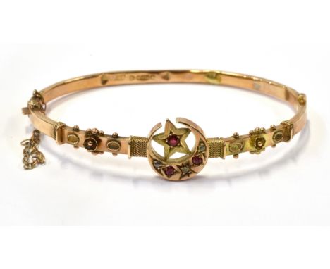 AN EDWARDIAN 9CT ROSE GOLD RED PASTE AND DIAMOND HOLLOW HINGED BANGLE the front designed as a star within a closed-crescent a