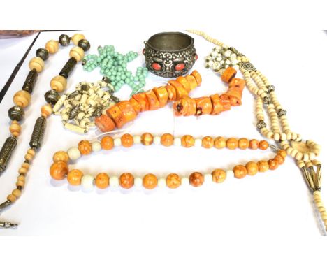 THREE NORTH AFRICAN BONE AND BEAD NECKLACES, A STAINED CORAL UNSTRUNG NECKLACE AND OTHER ITEMS including a broad bangle set w