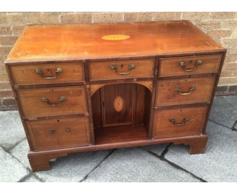 A MAHOGANY SIDE CABINET  with crossbanded and inlaid decoration, fitted with three drawers above recessed cupboard flanked by