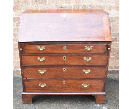 A GEORGE III MAHOGANY BUREAU  the fitted interior with central pull-out section having two 'secret' compartments, above four 