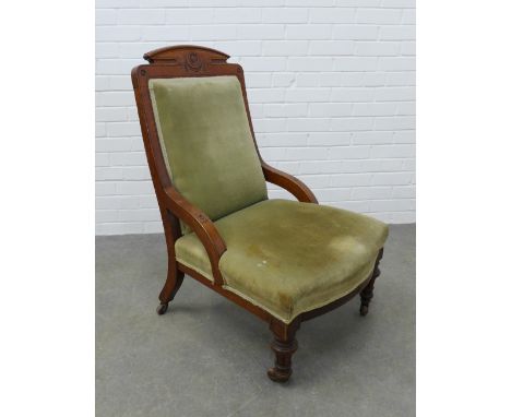 Late 19th century oak chair with arched and carved toprail, green velvet upholstered back and seat, brass caps and ceramic ca