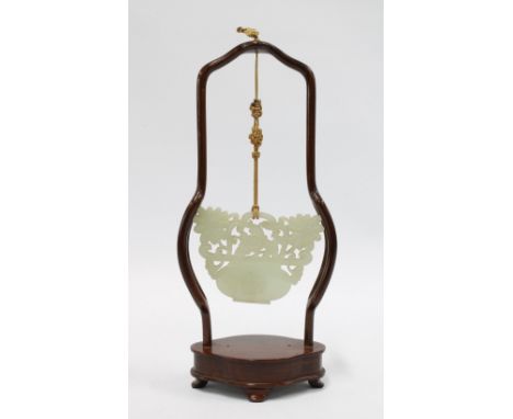 Carved jade plaque in the form of a basket of flowers, suspended within a chinoiserie wooden stand, 23cm high including stand