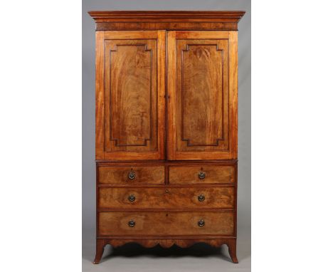A George III mahogany linen press. With panelled moulding to the doors, raised on a two over two chest base and with splay br