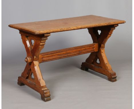 A Victorian Puginistic light oak library table. Raised on x-frame supports with trefoil panels and with moulded cross stretch