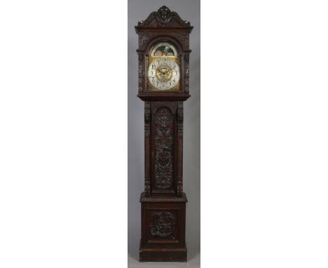 An imposing Victorian 8 day longcase clock in heavily carved oak case. With arch top gilt brass dial incorporating a moon rol