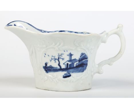 A Worcester flared cream boat with double scrolling handle and moulded with foliate cartouches. Painted in underglaze blue wi