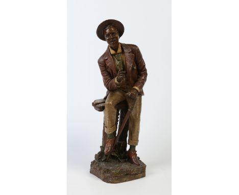 A 19th century painted terracotta figure by Bernhard Bloch. Modelled as a Negro gentleman smoking a cigar and holding a walki