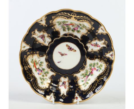 A Royal Worcester scalloped dessert dish. Scale blue ground, gilded and with shaped reserves containing fancy birds signed J.