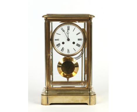 A large four glass brass mantel clock with enamel dial having Roman numeral markers and housing an eight day movement with an
