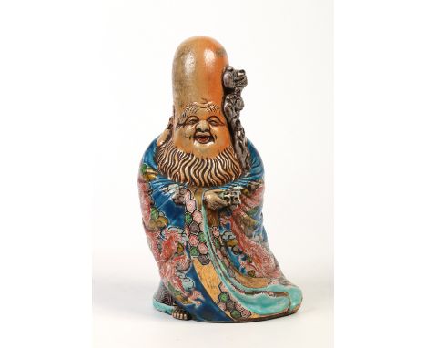 A Chinese glazed figure of a sage. Holding a gnarled staff and a scroll and dressed in flowing robes, 29.5cm.  Condition Repo